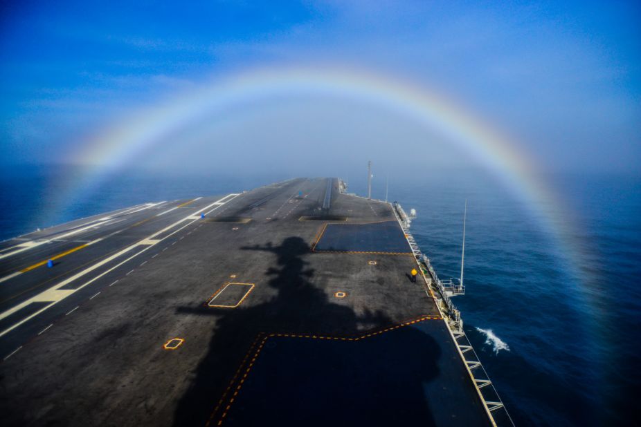 A rainbow forms over the bow of the Nimitz-class aircraft carrier USS John C. Stennis as the ship steams in the Pacific Ocean on February 3, 2015. 