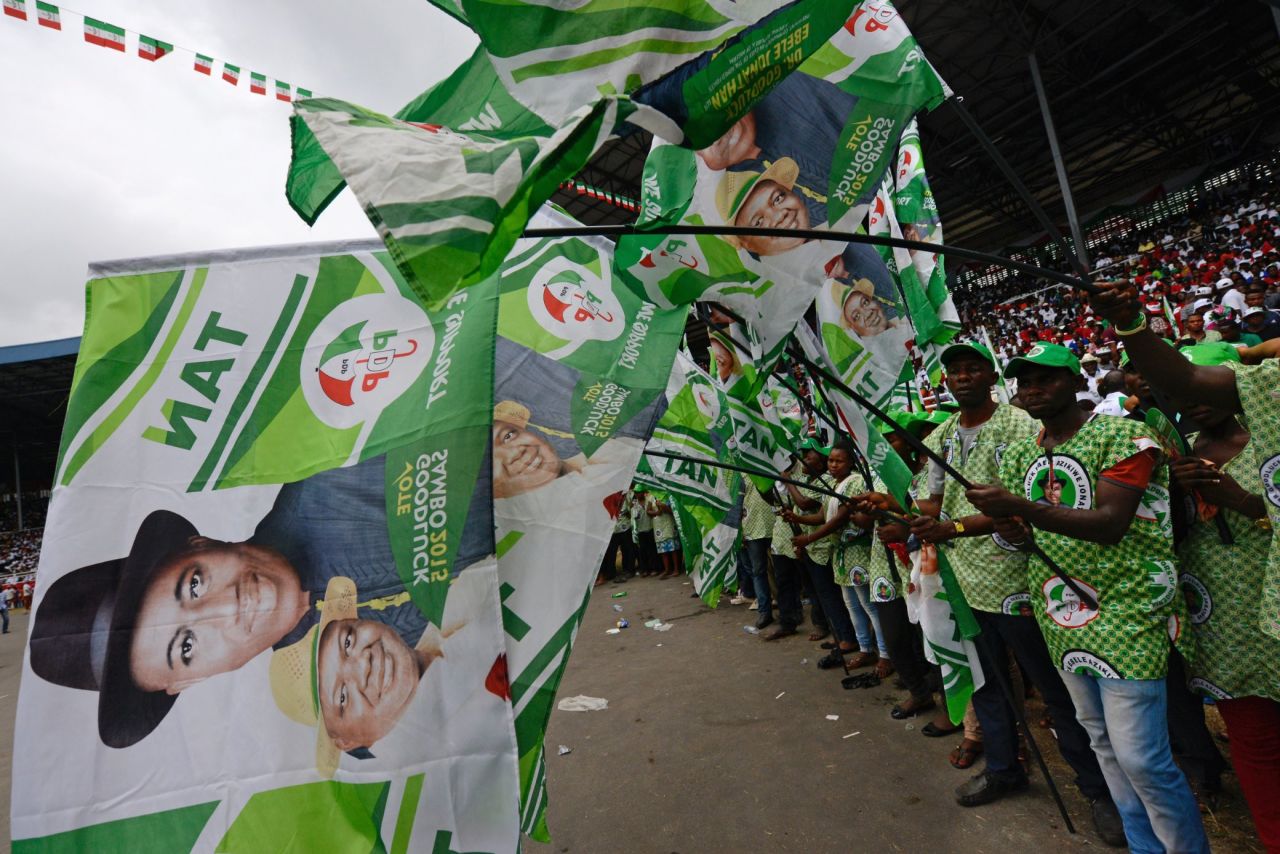 Supporters at a PDP rally in the Niger Delta wave flags bearing President Jonathan's portrait on January 28.<br />