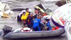 Rescue personnel work to free passengers from a TransAsia ATR 72-600 turboprop plane that crash-landed into a river outside Taiwan's capital Taipei in New Taipei City on February 4, 2015.