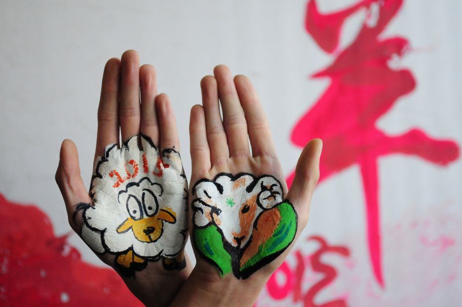 College students in China's Shandong province paint sheep on their hands on Tuesday, December 30.
