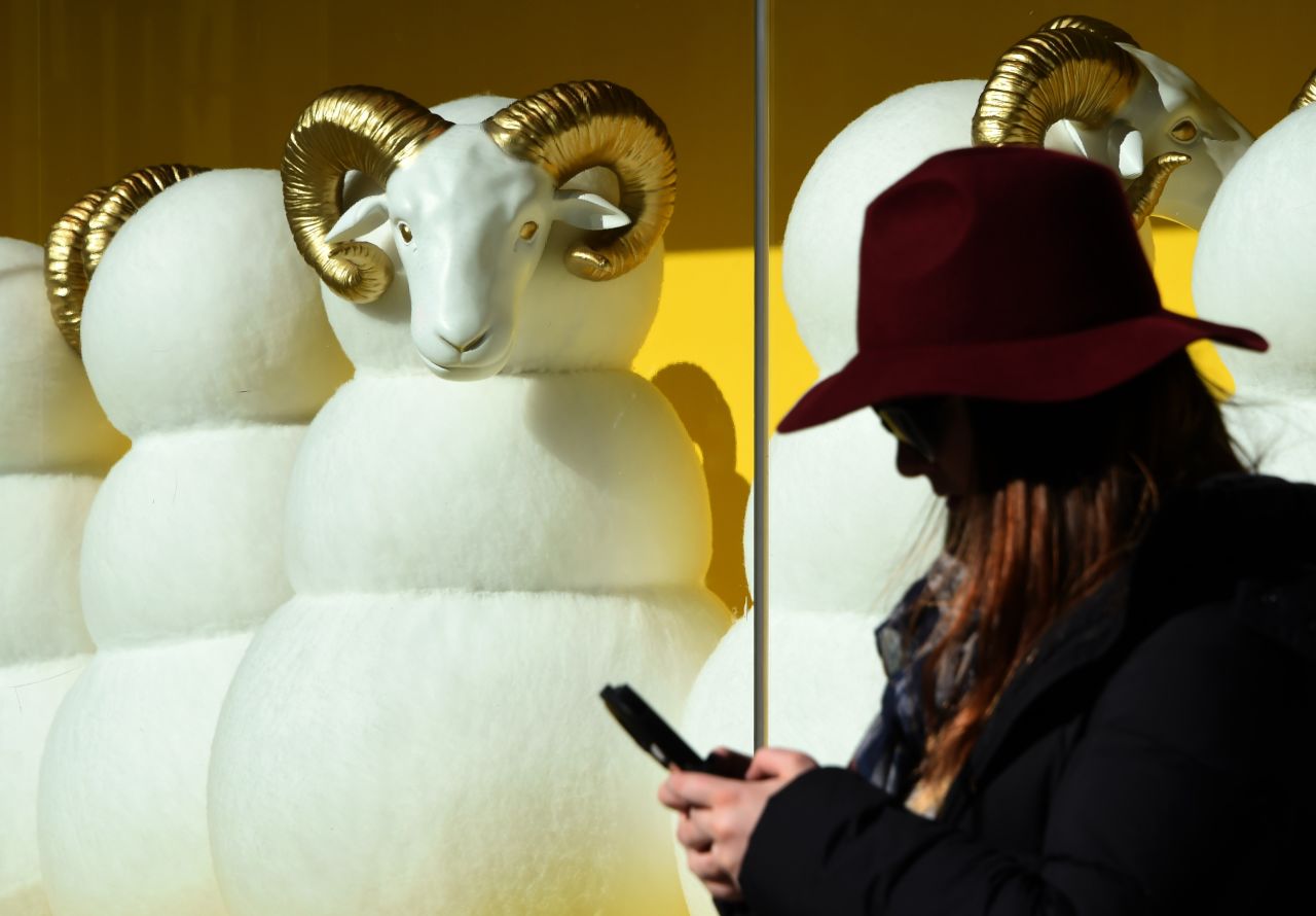 A pedestrian checks her cell phone in front of a department store in Tokyo on Friday, December 26.