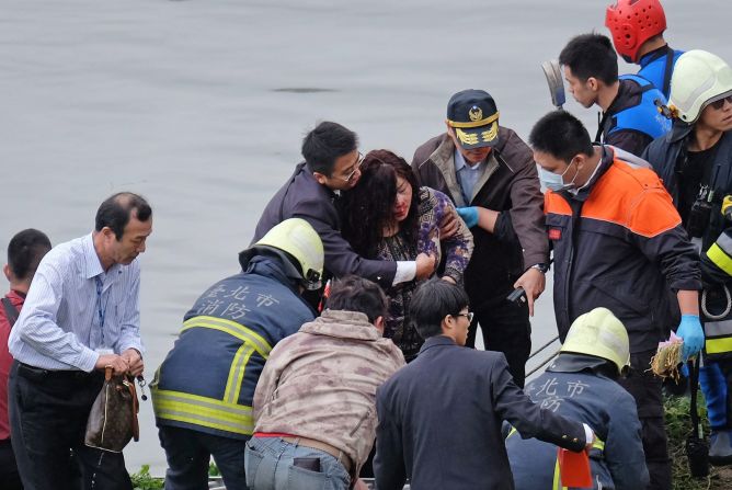 Emergency personnel help an injured passenger onto land on February 4.