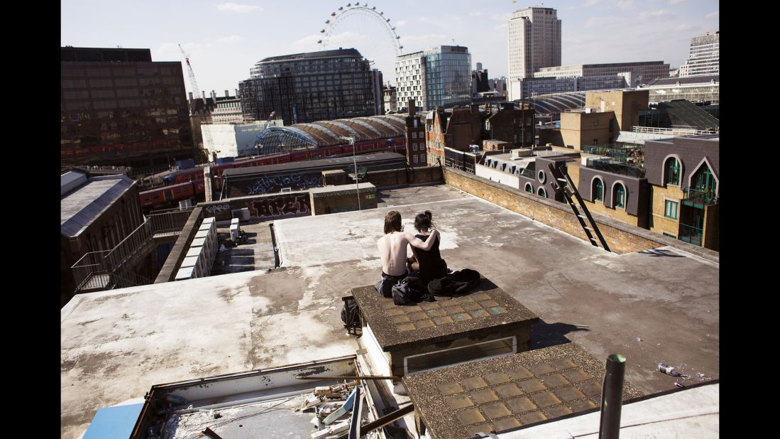A couple sits on the rooftop of a squat in London called "The Castle." Once used as a five-story office, the building has become home to more than 100 squatters -- people who don't pay rent.