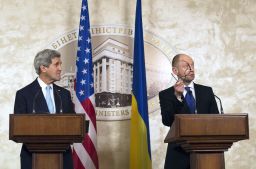 Ukraine Prime Minister Arseniy Yatsenyuk, in Kiev with U.S. Secretary of State John Kerry, offers his glasses to Russian President Vladimir Putin.