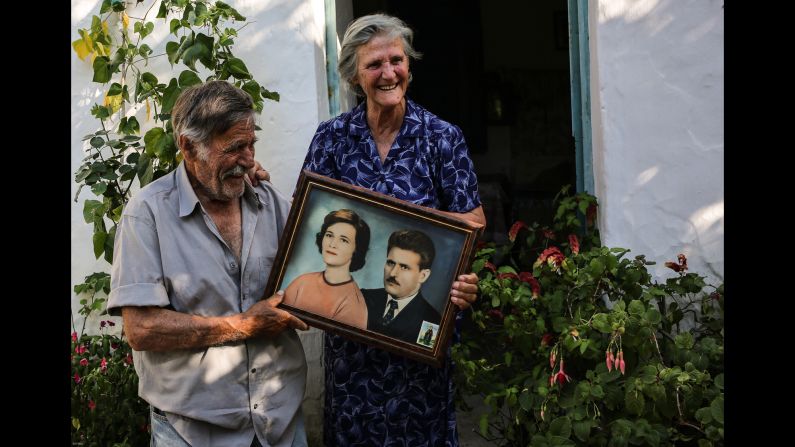 The term <a  target="_blank" target="_blank">"Blue Zones"</a> has been used to describe small pockets of the world where people, on average, live longer and healthier lives. One such Blue Zone is the Greek island of Ikaria, where octogenarians Alexandro and Antiiopi Koufadakis live. The couple, holding a portrait here of their younger selves, have been married for 61 years.