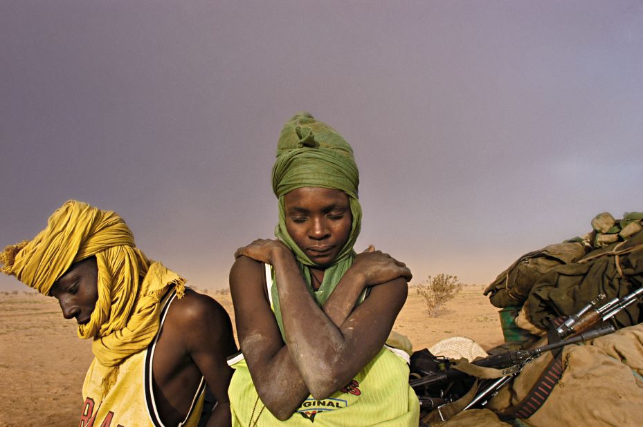 Soldiers with the Sudanese Liberation Army wait by their truck while struck in the mud and hit by a sandstorm in North Darfur, Sudan, August 21, 2004.
