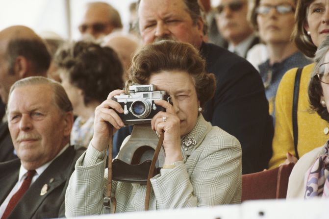 Queen Elizabeth II takes pictures of her husband during a horse show in Windsor, England, on May 16, 1982. 
