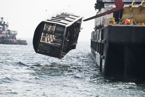 Photographer Stephen Mallon captured pictures of disused subway cars being loaded up onto a barge and thrown into the Atlantic Ocean to make an artificial coral reef. 