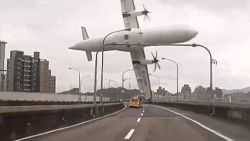 This screen grab taken from video provided courtesy of TVBS Taiwan on February 4, 2015 shows a TransAsia ATR 72-600 turboprop plane clipping an elevated motorway and hitting a taxi (C) before crashing into the Keelung river outside Taiwan's capital Taipei in New Taipei City. The low-flying passenger plane, TransAsia Flight GE235 with 58 people on board, clipped the bridge and plunged into the river outside Taiwan's capital with at least 11 feared dead and many trapped inside.