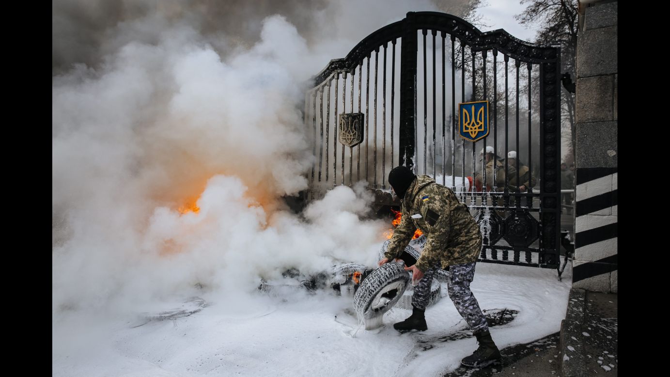 A Ukrainian serviceman with the Aydar volunteer battalion prepares to throw a tire over the gates of the Ukrainian Defense Ministry during a demonstration in Kiev on Monday, February 2. According to local media, Aydar volunteers were protesting against the disbandment of their battalion.
