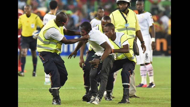 Security officers grab a supporter who got onto the pitch during the African Cup of Nations semifinal between Equatorial Guinea and Ghana on Thursday, February 5.  