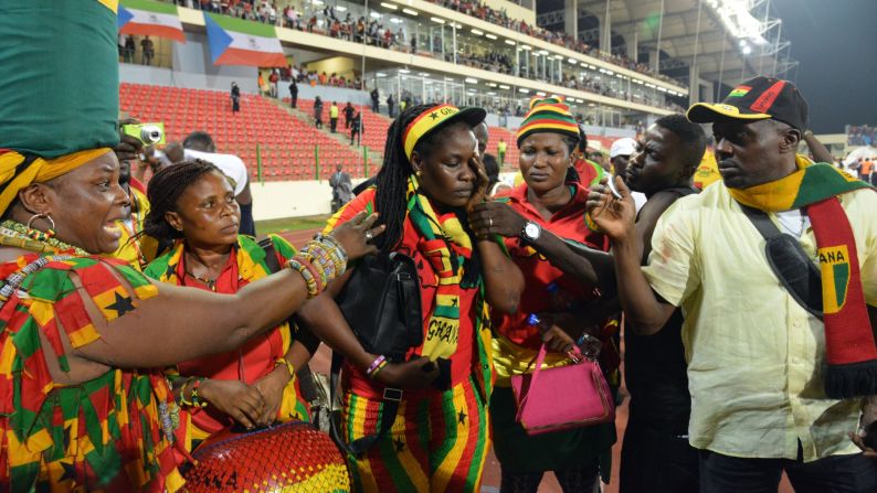 A Ghanaian fan holds her face while standing beside the pitch after the match, which was played in Malabo, Equatorial Guinea.