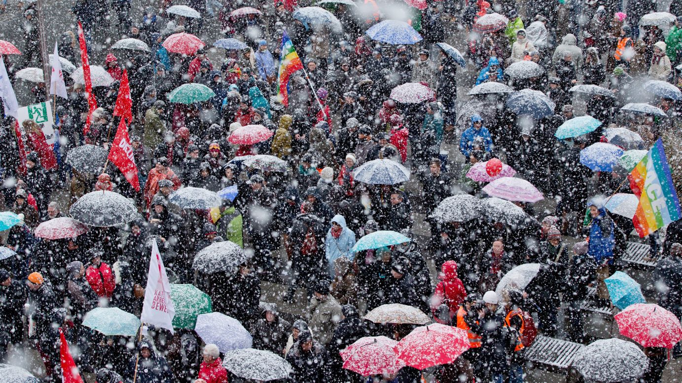 People hold a rally against racism while snow falls Friday, January 30, in Nuremberg, Germany.
