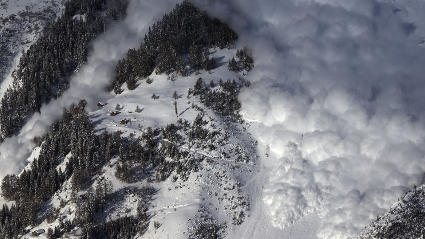 An artificially triggered avalanche thunders down a mountainside in Anzere, Switzerland, on Tuesday, February 3. It was part of a scientific test for the Swiss Institute for Snow and Avalanche Research.