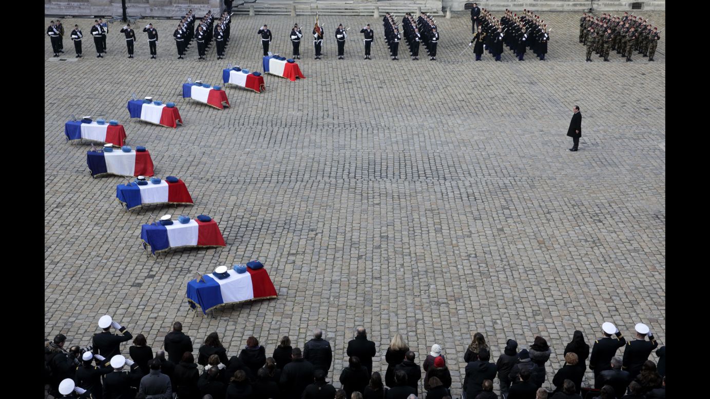 French President Francois Hollande pays his respects Tuesday, February 3, near the flag-draped coffins of nine French Air Force members who died in an accident last month in Albacete, Spain.