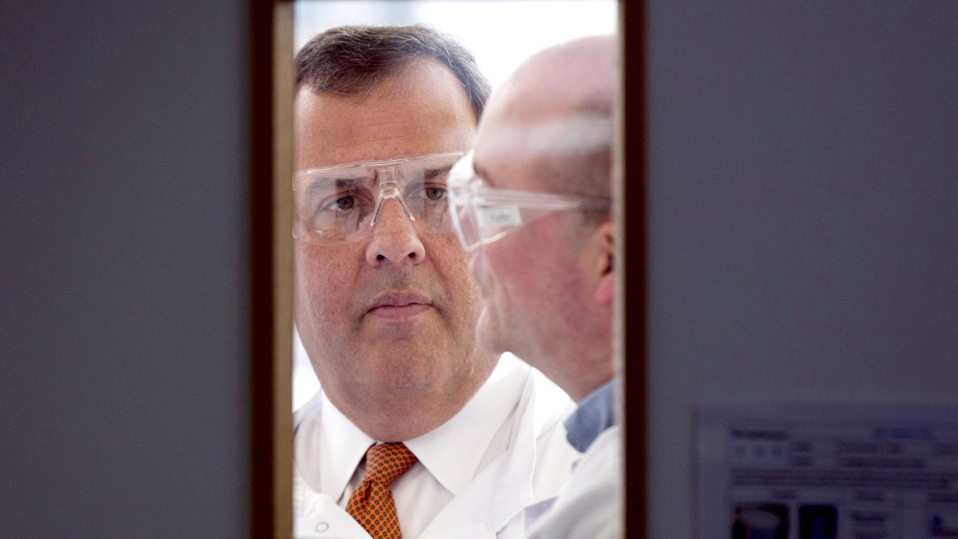 New Jersey Gov. Chris Christie, left, wears safety glasses during his visit to the headquarters of One Nucleus, a life science company in Cambridge, England, on Monday, February 2.