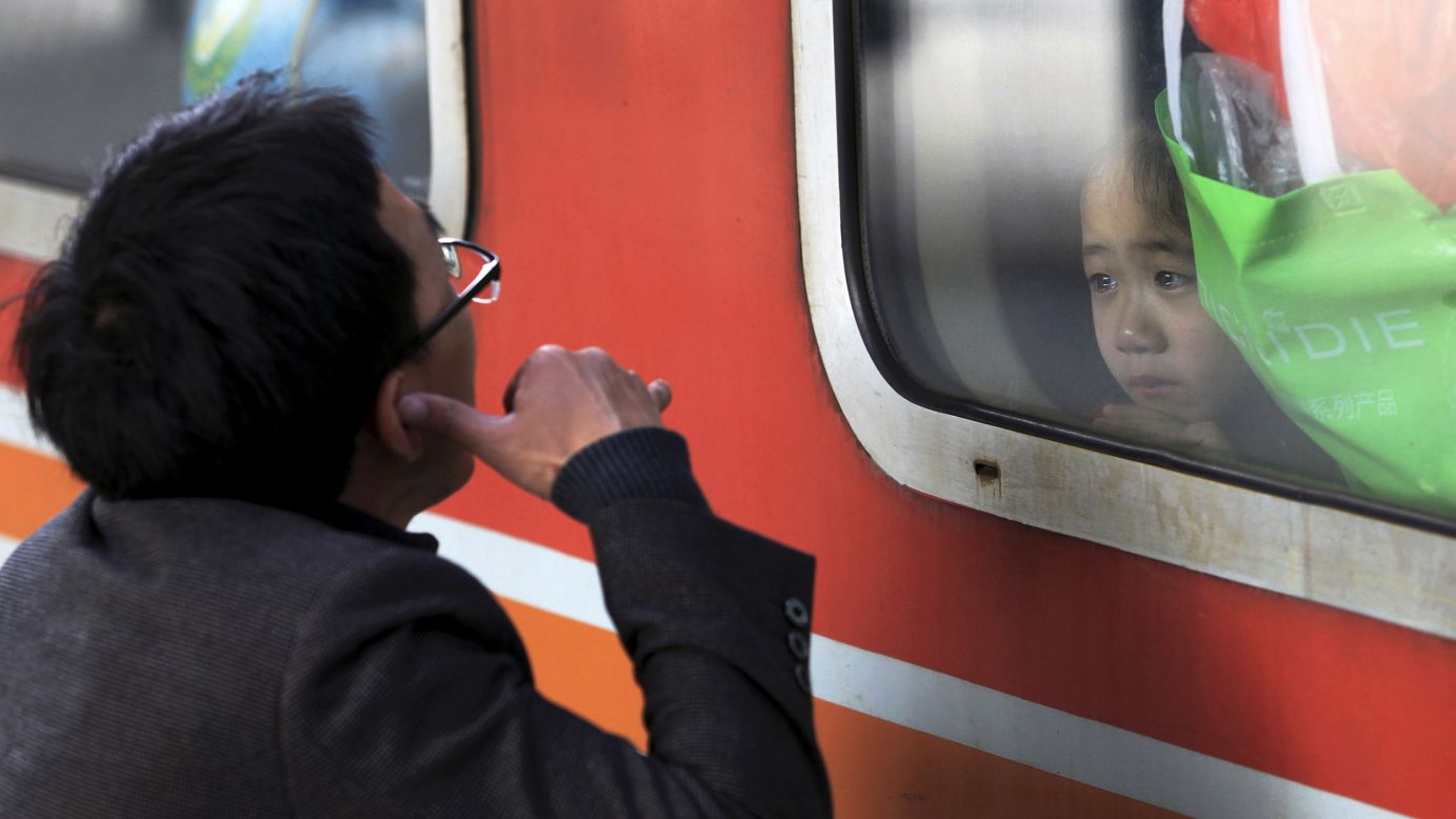 A man gestures to his daughter as she and her mother, not pictured, leave a railway station in Shenzhen, China, on Monday, February 2.