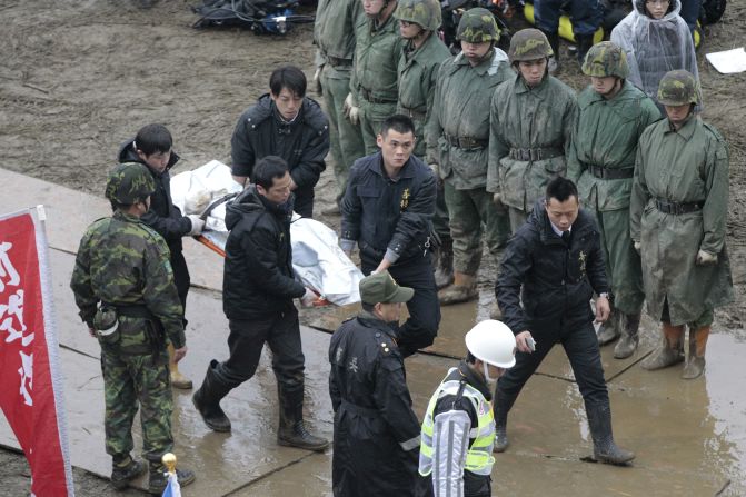 Emergency personnel carry a body recovered from the water on February 6.