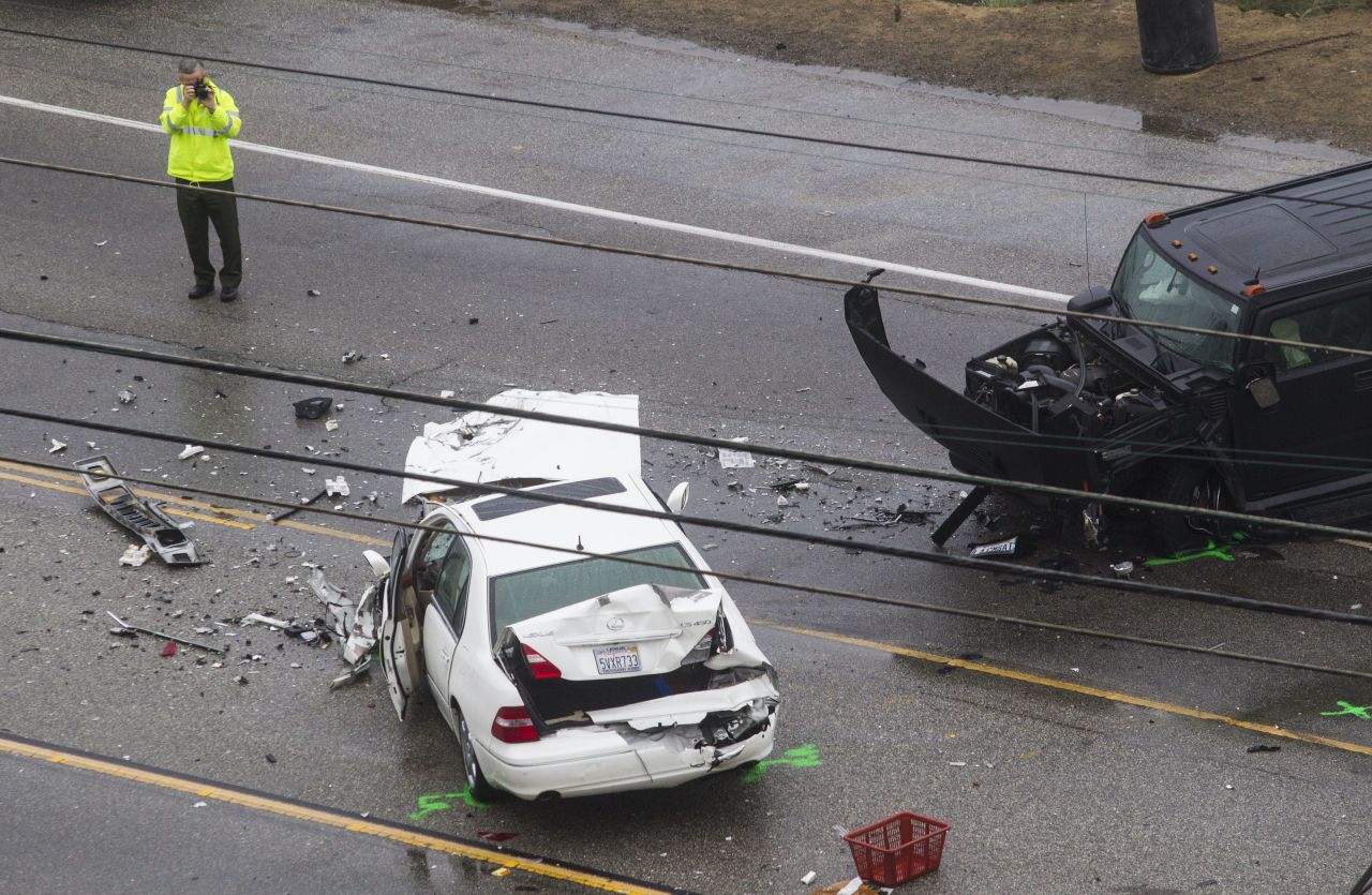 A Los Angeles County Sheriff's deputy photographs the scene. One of the drivers involved in the wreck was killed on Pacific Coast Highway near Corral Canyon Road, a news release stated.