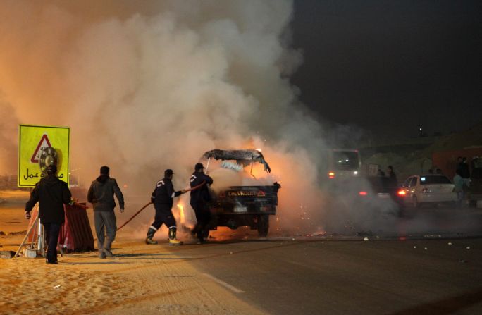 Firefighters try to put out the burning vehicle. 