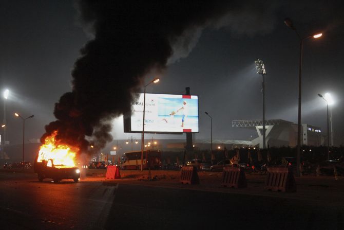 A pickup truck burns outside the stadium. 