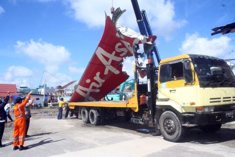 Workers load the tail of the plane onto a truck February 7 at the Kumai seaport.