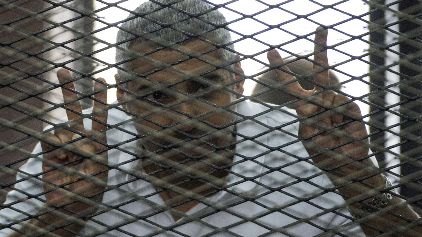 File: Al-Jazeera journalist Mohamed Fahmy, pictured under detention in June 2014, is suing the network for $100 million.