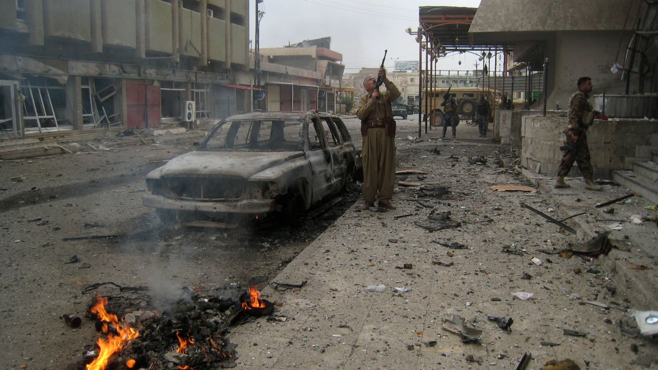 In this Friday, Jan. 30, 2015 file photo, Kurdish peshmerga fighters surround extremists inside a hotel near police headquarters in the oil-rich city of Kirkuk, 290 kilometers (180 miles) north of Baghdad, Iraq. While Islamic State fighters have been forced to retreat from Kobani, the strategic town on Syria's border with Turkey, they appear far from beaten in northern Iraq. Along the Kurds' shifting front lines, it's a tenuous hold. In Kirkuk, Kurdish forces have suffered painful losses from incessant IS guerrilla activity. (AP Photo, File)
