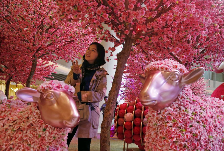 A woman poses for a photograph among decorations in Hong Kong on Friday, February 6. 