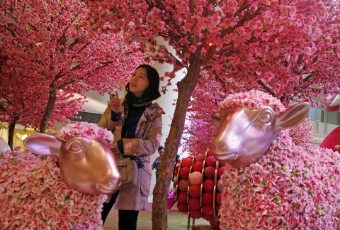 A woman poses for a photograph among decorations in Hong Kong on Friday, February 6. 