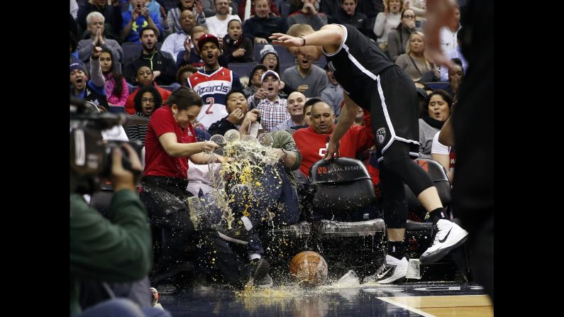 Waitress Deila Barr loses a tray of beer after Brooklyn Nets center Mason Plumlee ran into her while chasing a loose ball Saturday, February 7, in Washington.