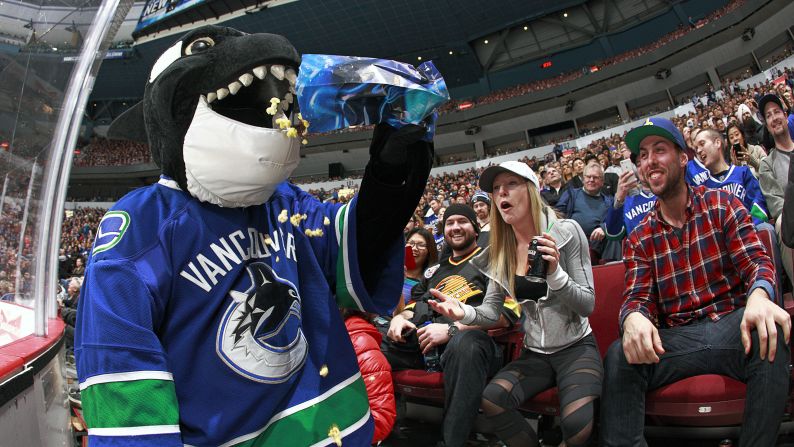 Fin the Whale, the mascot of the NHL's Vancouver Canucks, feasts on a fan's popcorn during a game on Tuesday, February 3.