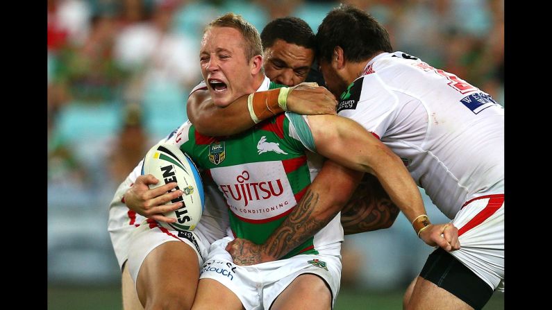 Jason Clark of the South Sydney Rabbitohs is tackled during a preseason match against the St. George Illawarra Dragons on Saturday, February 7. The two teams tied 12-12 in Sydney in what was the Charity Shield match for the National Rugby League.