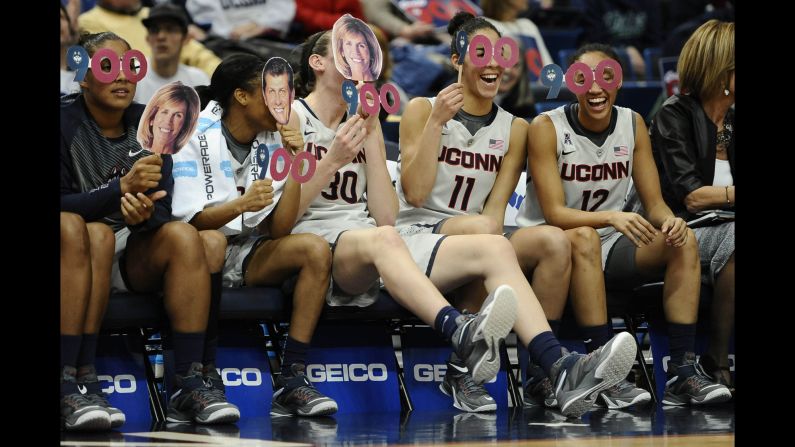 Connecticut basketball players share a lighthearted moment on the bench during the second half of a game against Cincinnati on Tuesday, February 3. Connecticut won 96-36 to earn head coach Geno Auriemma his 900th career victory.