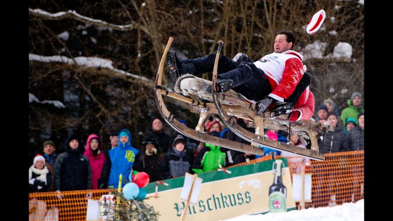 Two costumed participants ride their sled Sunday, February 8, during the traditional Schnablerrennen race in Gaissach, Germany. 