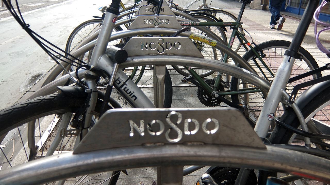Cycle parking spaces are in short supply in Seville. There are some purpose-built racks. These carry the emblem "NO8DO," an official motto said to mean "Seville has not abandoned me."