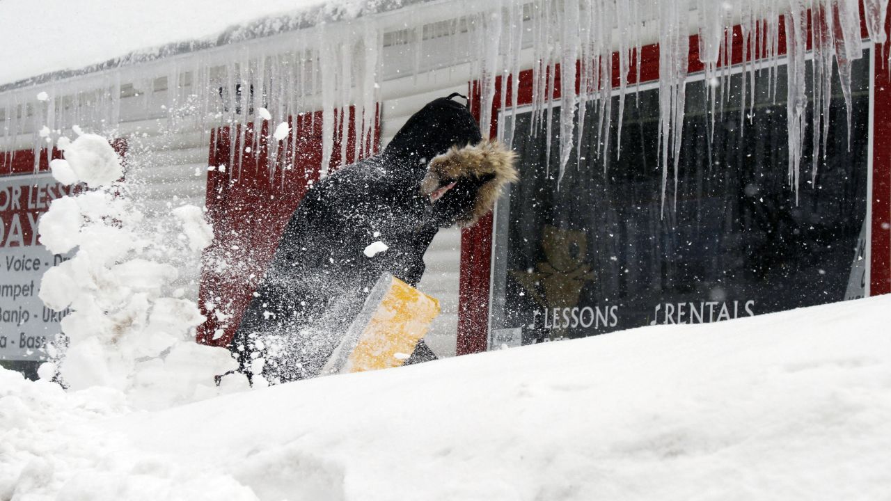 Corbit Larson clears snow in front of his Centre Music House store in Framingham, Massachusetts, on February 9.