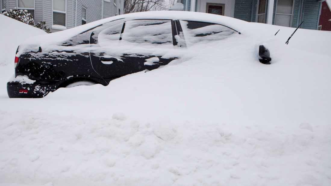 A car is buried in snow in the Dorchester neighborhood of Boston on February 9.