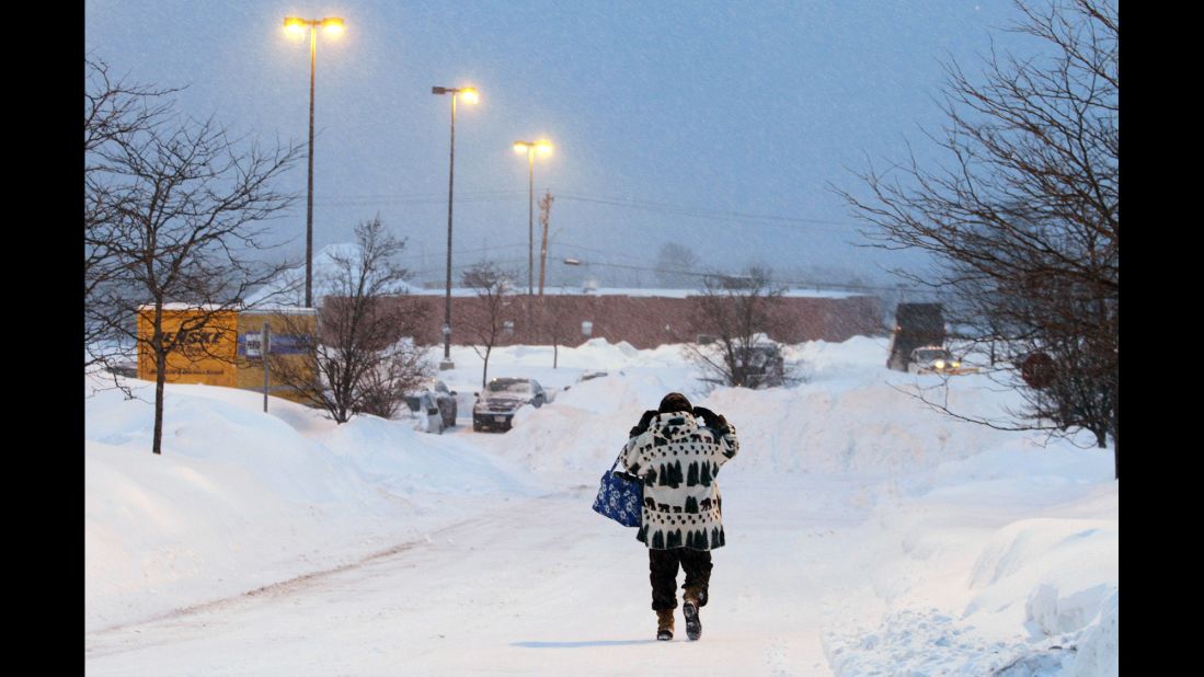 A woman walks down a snow-covered road in Marlborough early on February 9.