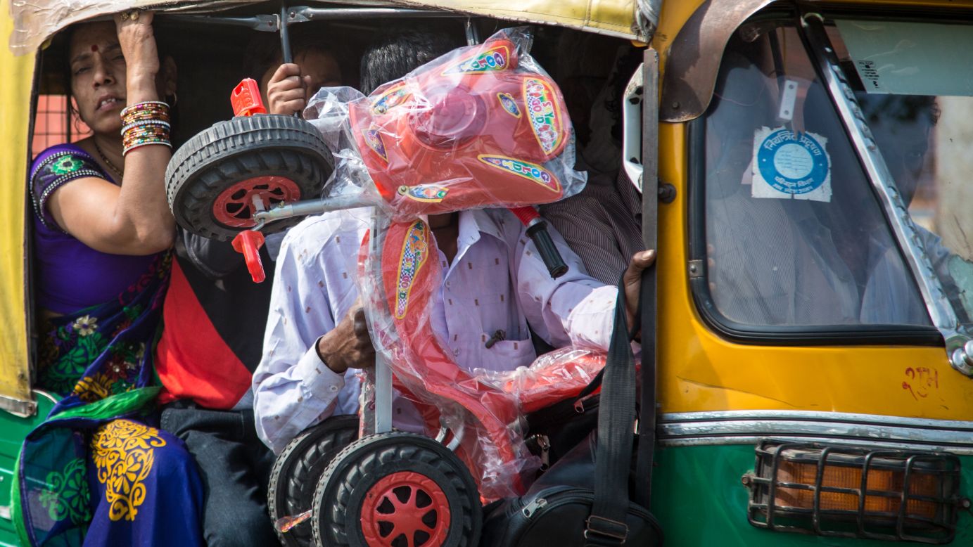 A cramped tuk-tuk navigates the busy streets of Agra.
