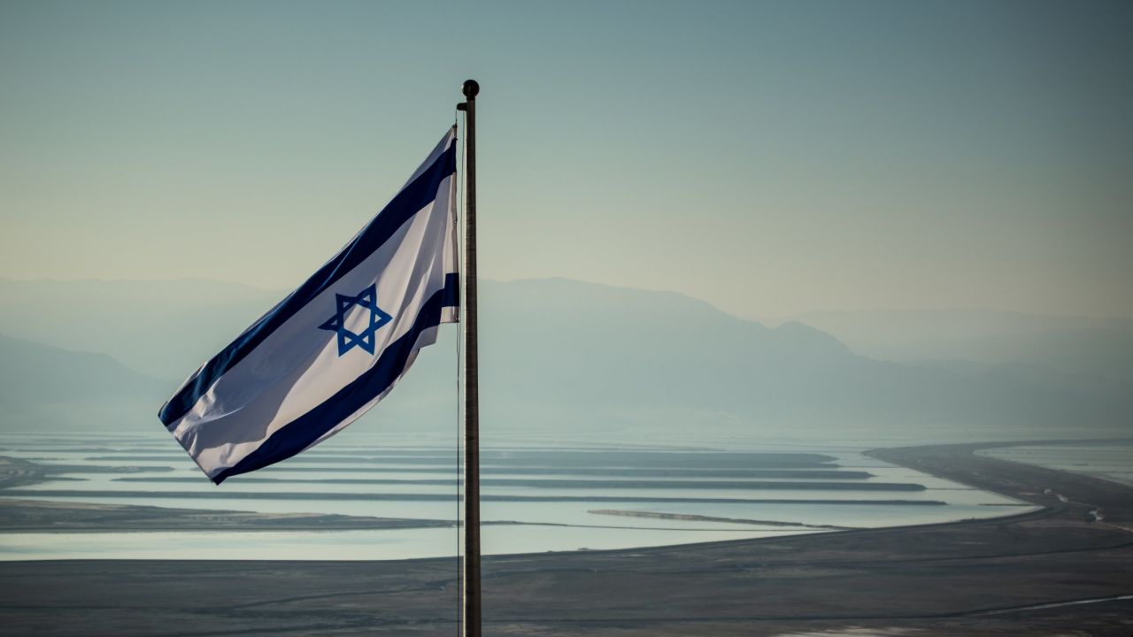 An Israeli flag waves near the evaporation ponds of the Dead Sea, a series of shallow-water reservoirs that capture the runoff from the southern edge of the Dead Sea.