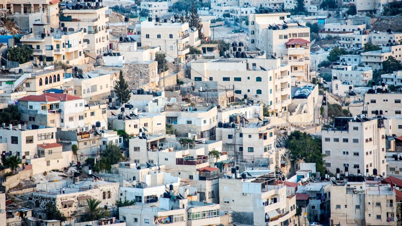 Hundreds of houses and buildings fill a hillside outside the walls of the Old City of Jerusalem.