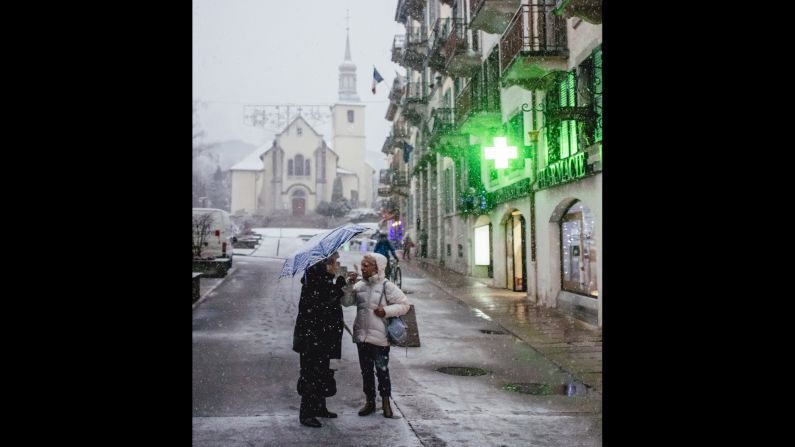 Women chat along the quaint streets of Chamonix during the first big snowfall of the season.