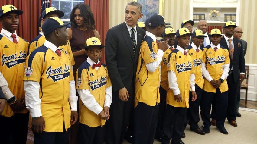 US President Barack Obama and First Lady Michelle Obama greet the 2014 US champion Jackie Robinson West All Stars Little Baseball League in the Oval Office of the White House in Washington, DC on November 6, 2014. AFP PHOTO/YURI GRIPAS        (Photo credit should read YURI GRIPAS/AFP/Getty Images)