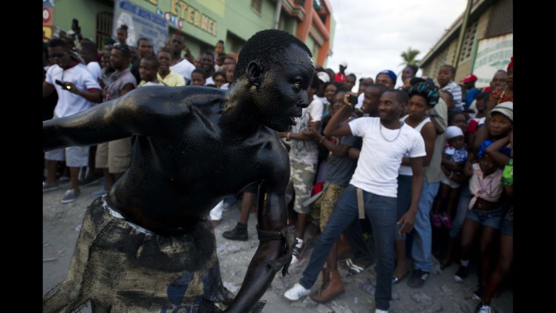 A reveler painted in motor oil performs during Carnival celebrations in Carrefour, Haiti, on Friday, February 6.