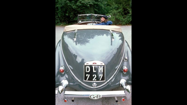 An avid car collector, Clapton is captured here deciding to buy a 1930s-era green Lancia Astura.