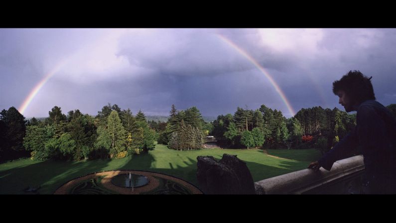 Harrison admires a rainbow from a porch at Friar Park.
