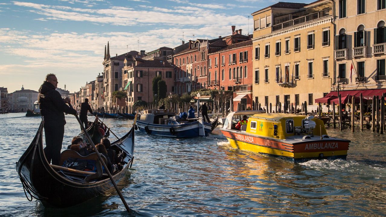 A gondolier takes some tourists out on an early morning punt along the Grand Canal.