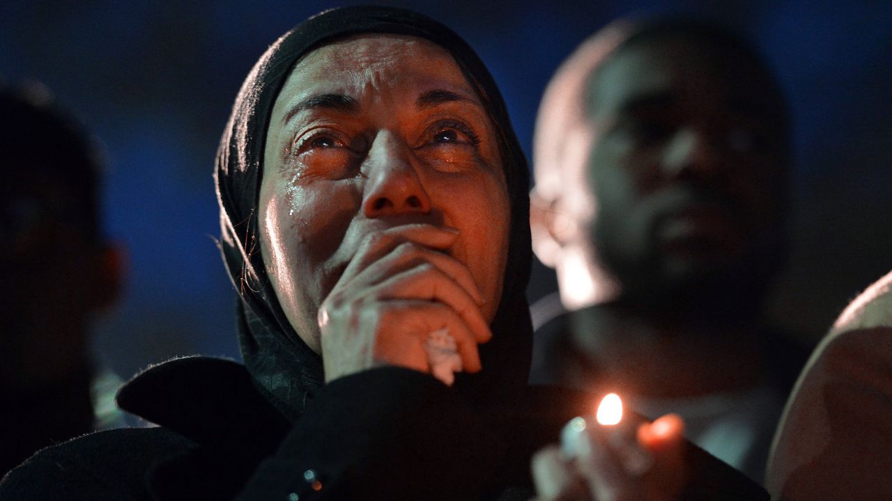 A woman cries during a vigil on Wednesday, February 11, as she watches photos projected on a screen of three people killed at an apartment near the University of North Carolina at Chapel Hill. Much of the college community is grieving at vigils and prayer services after three Muslim students -- Deah Shaddy Barakat, 23; his wife, Yusor Mohammad, 21; and her sister, Razan Mohammad Abu-Salha, 19 -- were found shot to death Tuesday, February 10. Craig Stephen Hicks has been charged with murder in their deaths.