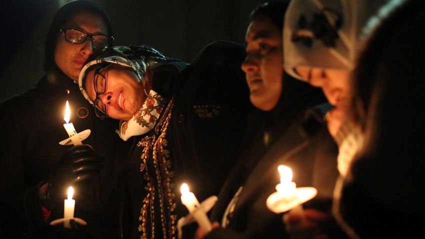 Nida Allam, a senior at North Carolina State University, rests her head on Asheen Allam during a vigil in Chapel Hill on February 11.